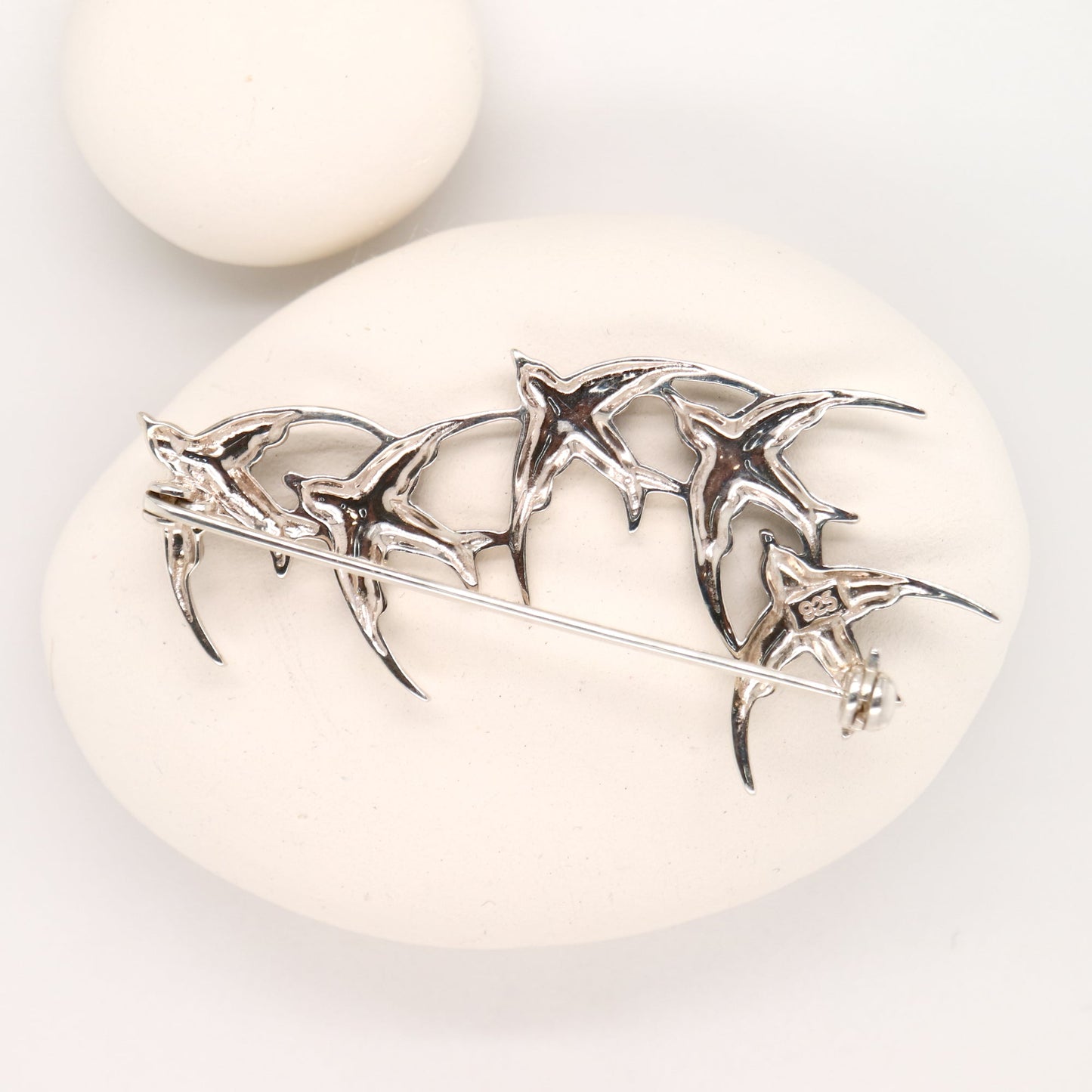 Silver brooch with starfish design on a white stone