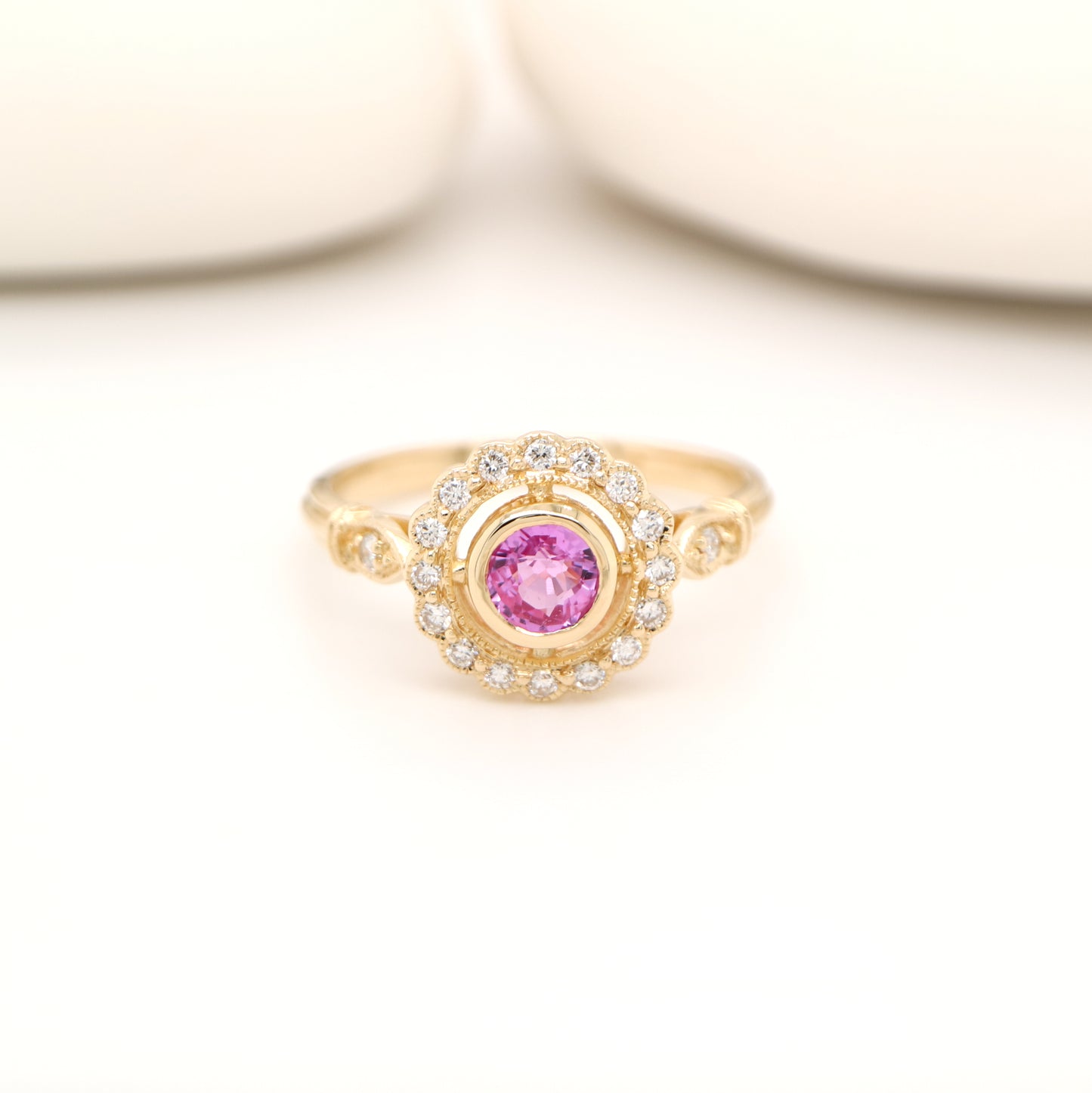 Pink sapphire with diamond halo in yellow gold ring