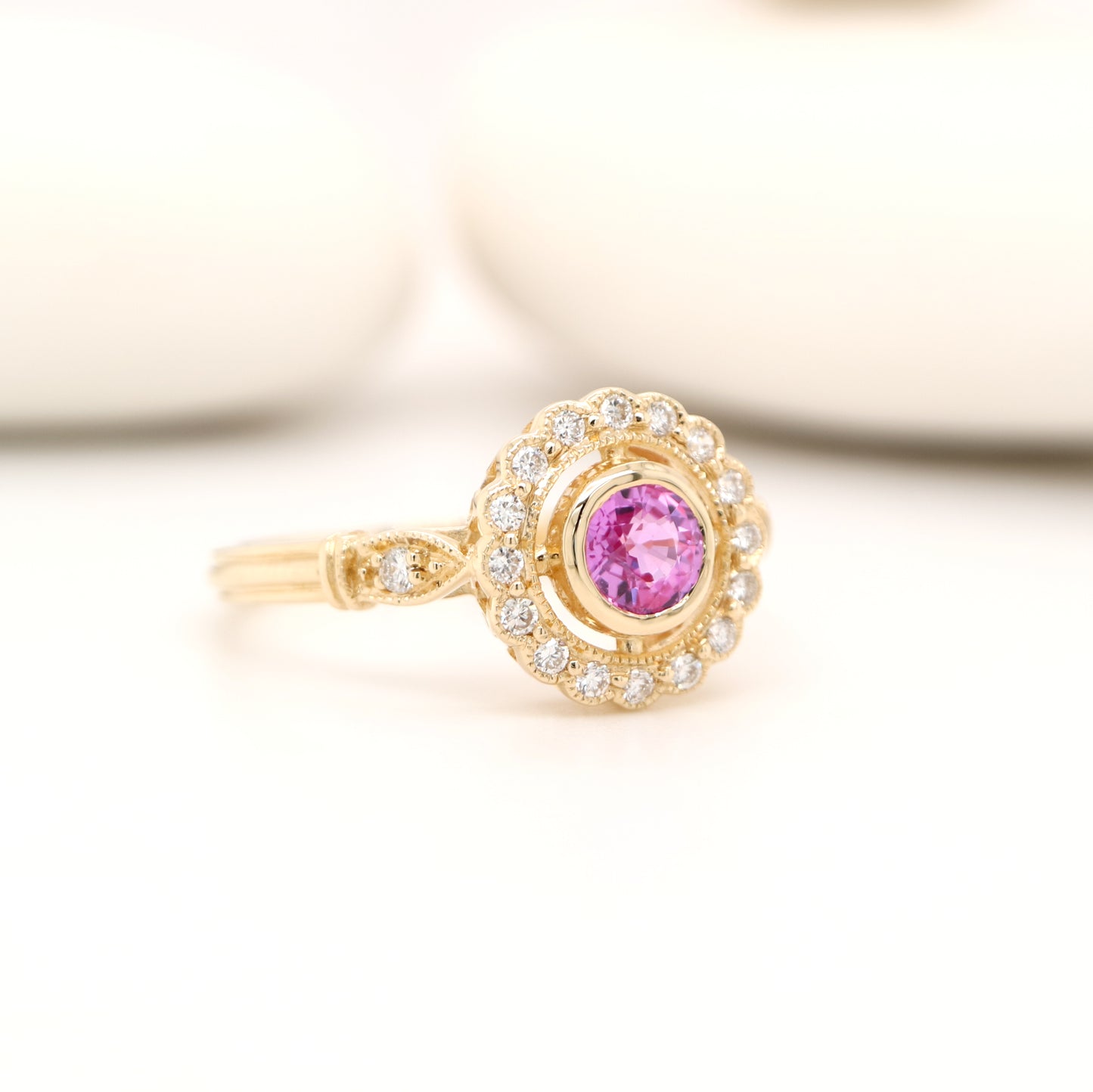 Pink sapphire with diamond halo in yellow gold ring