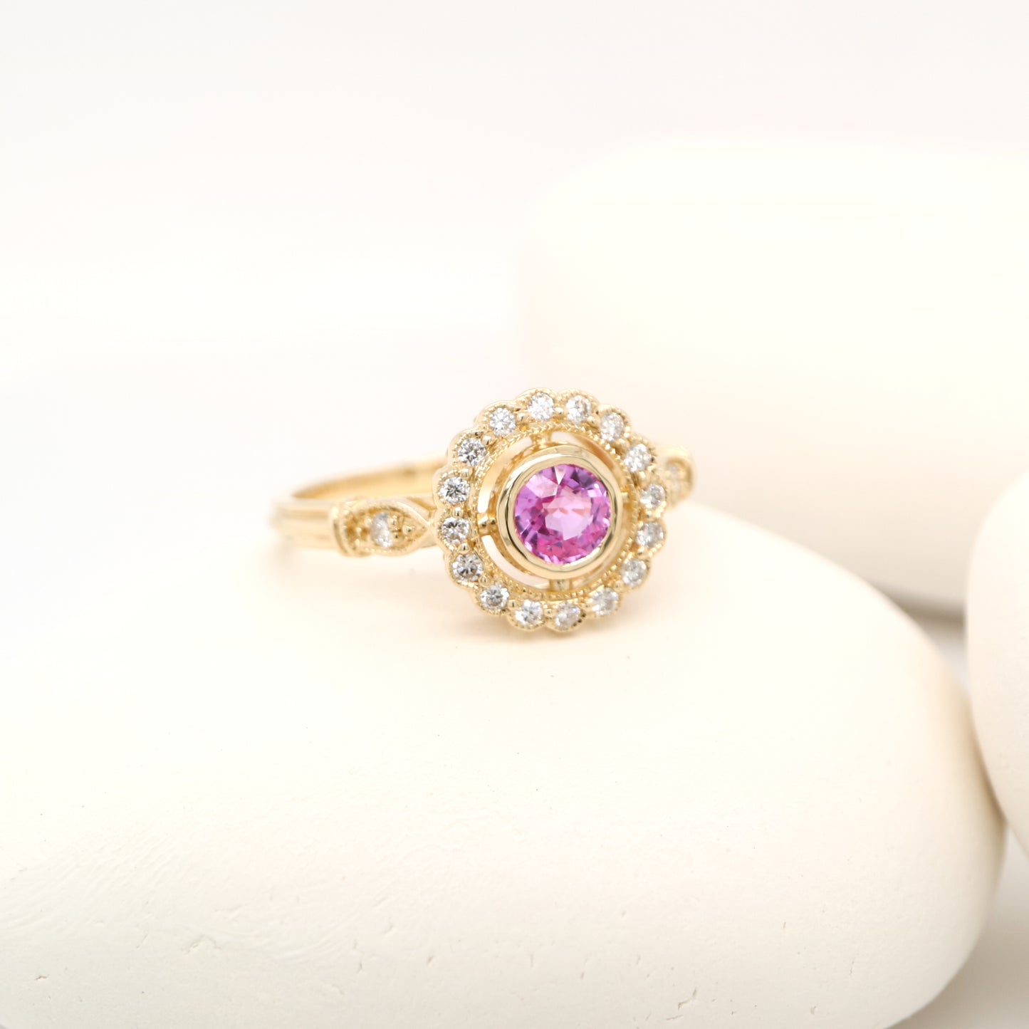 Pink sapphire with diamond halo in yellow gold ring