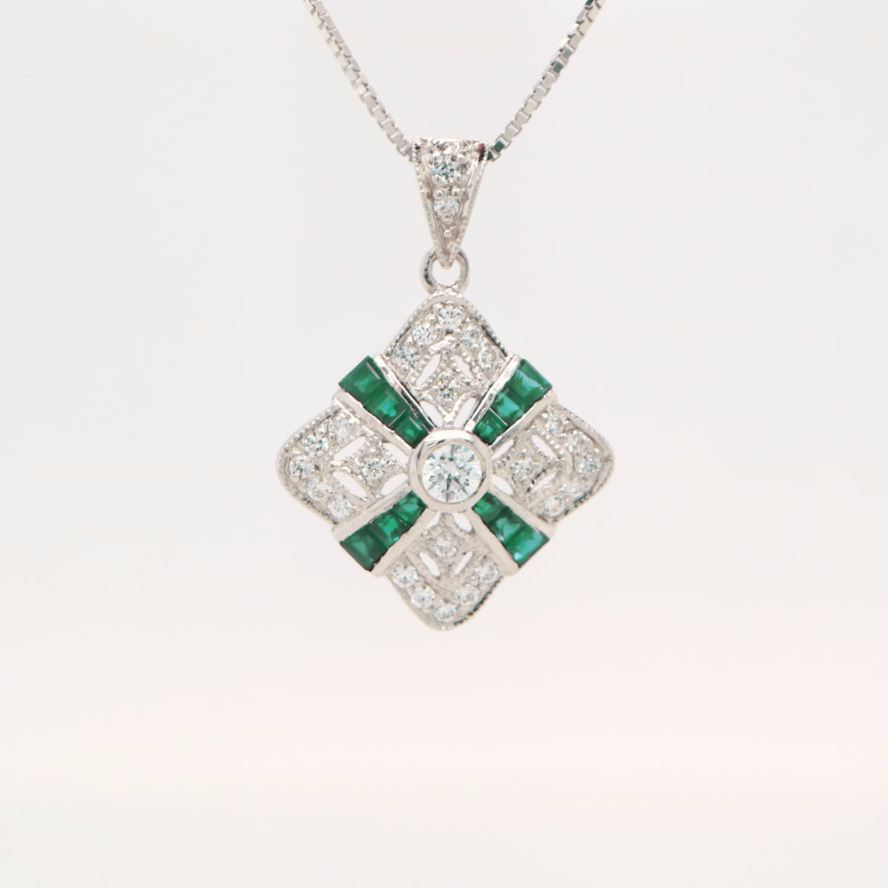 Art deco natural emerald and diamond pendant in cross over design set in 9k white gold