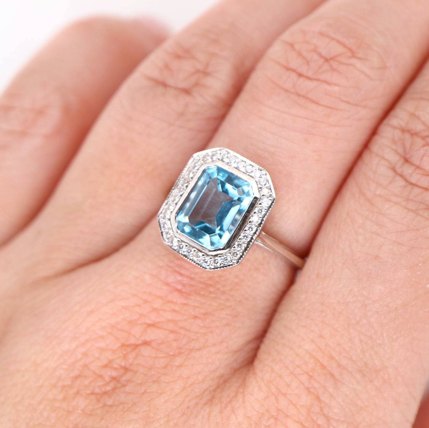 Blue topaz with diamond halo in white gold ring