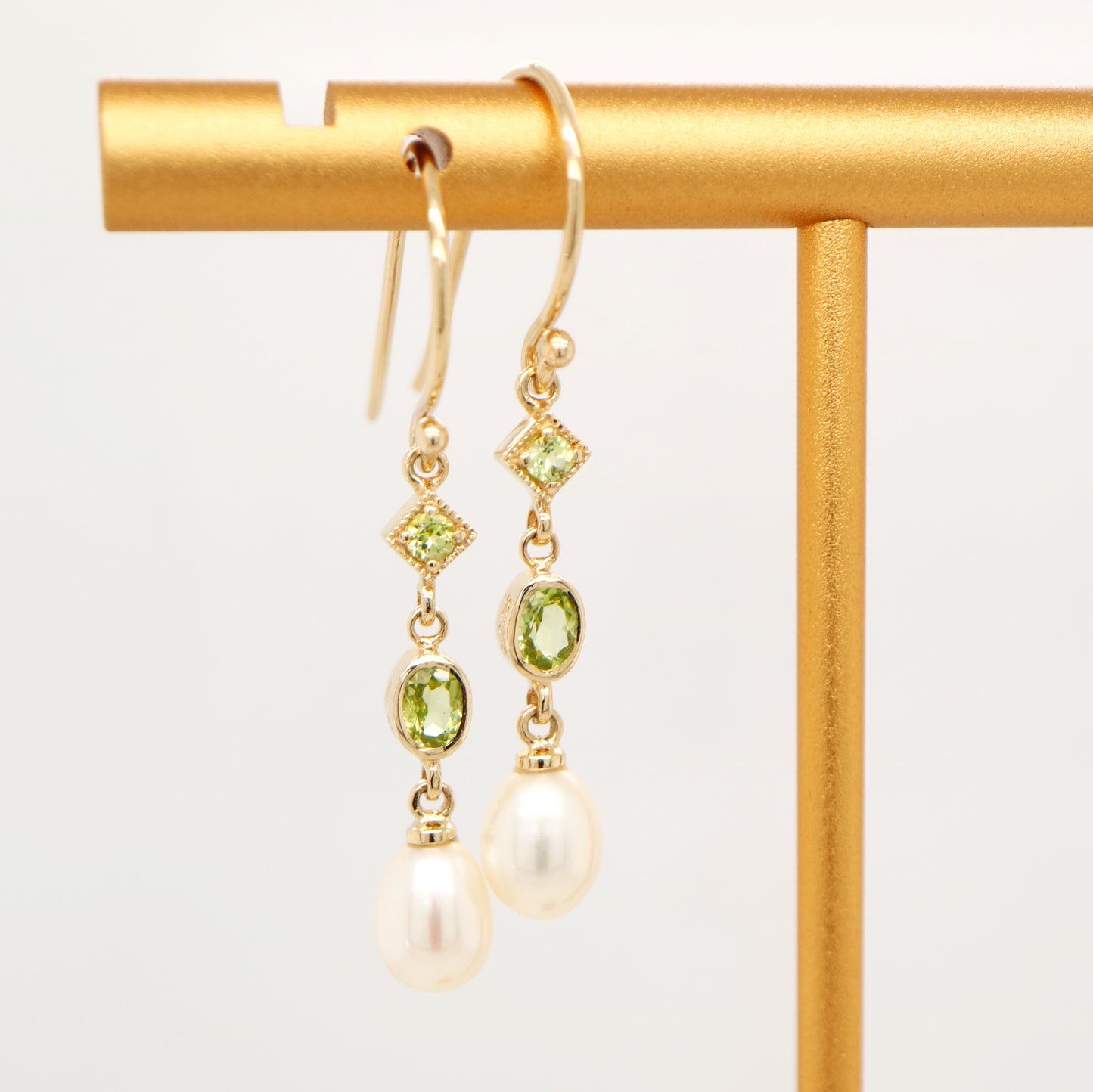 Hook dangle earrings with peridot and freshwater pearl drop in 9k yellow gold