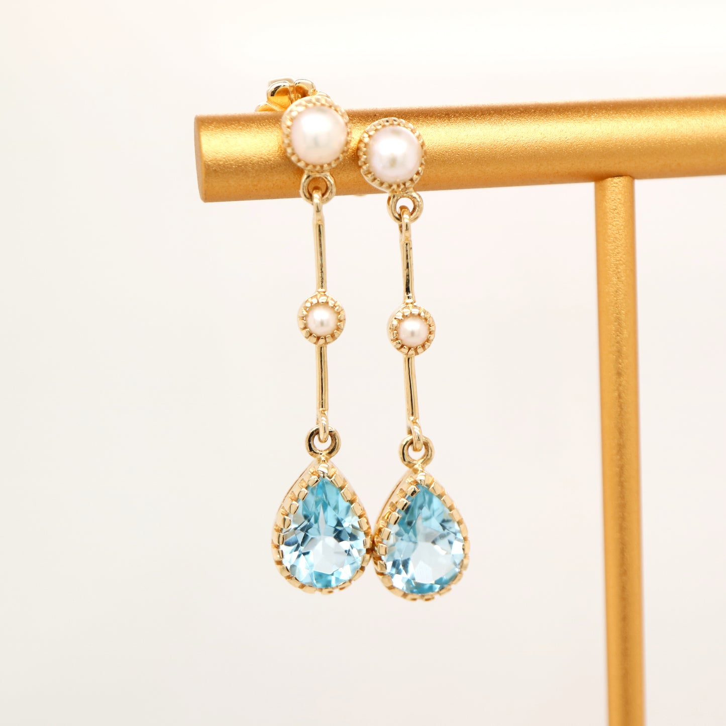 Freshwater pearl with blue topaz drop earrings in 9k yellow gold