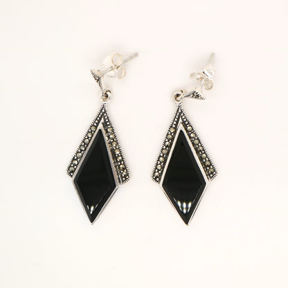 Pair of black diamond-shaped earrings with silver accents on a white background