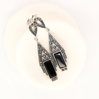 Black and silver earrings on a white background