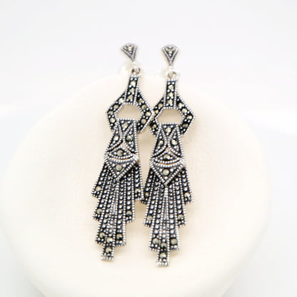 Pair of black and silver beaded earrings on a white background