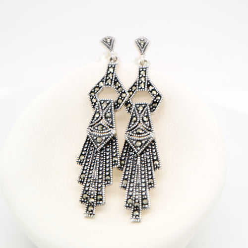 Pair of black and silver beaded earrings on a white background