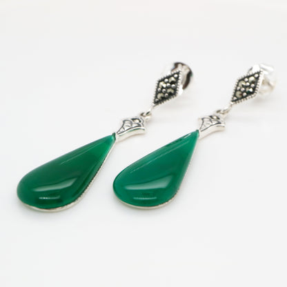 Green teardrop earrings with silver accents on a white background