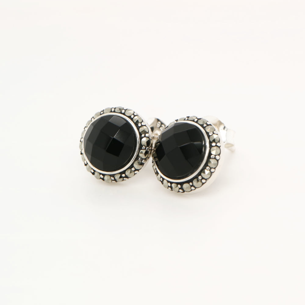 Pair of black gemstone earrings with silver accents on a white background