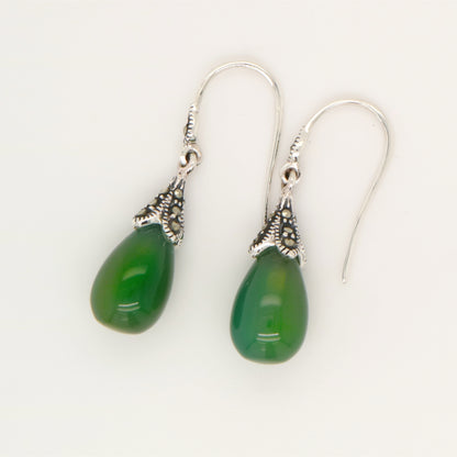 Green teardrop earrings with silver hooks on a white background
