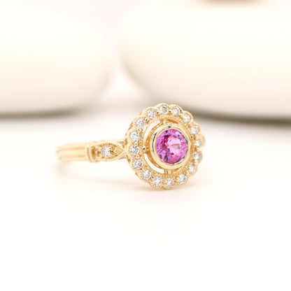 Pink sapphire with diamond halo in yellow gold ring