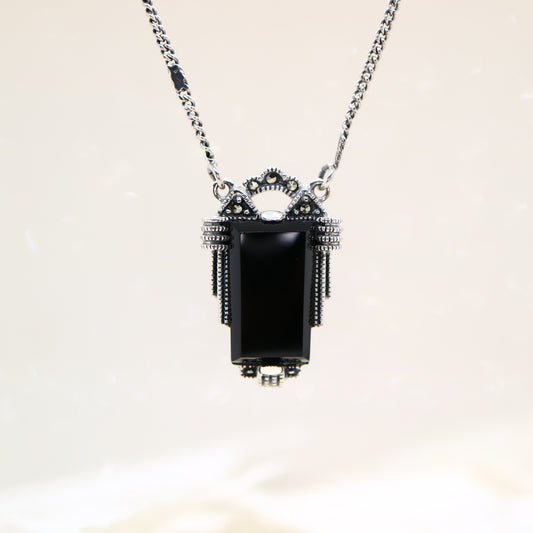 Necklace with a black pendant on a light background
