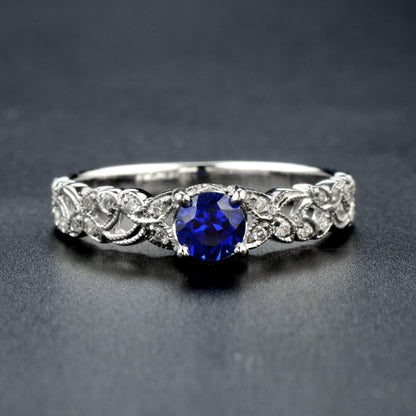 Sapphire solitaire ring with diamond in white gold with leaf pattern