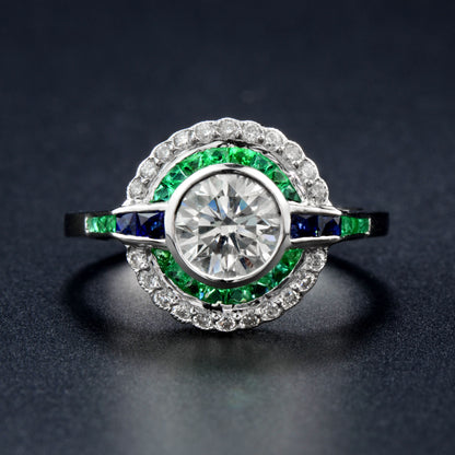 Moissanite and emerald target ring with sapphire accents in white gold