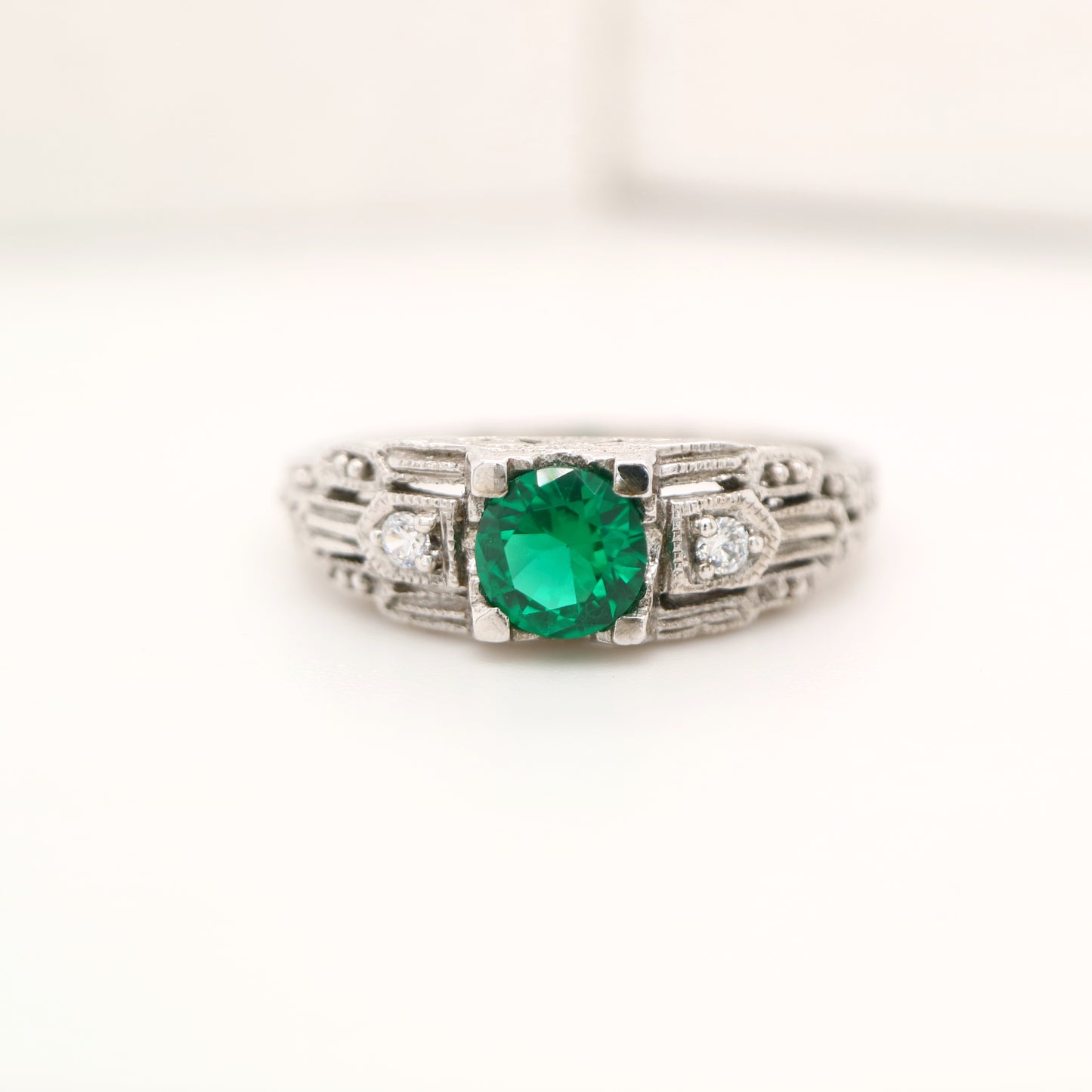 Art deco white gold ring with center emerald and shoulder diamond