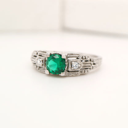 Art deco white gold ring with center emerald and shoulder diamond