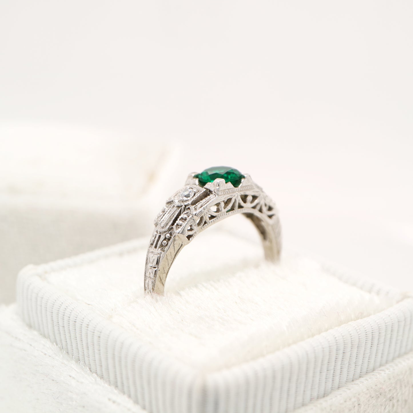 Art deco white gold ring with center emerald and shoulder diamond