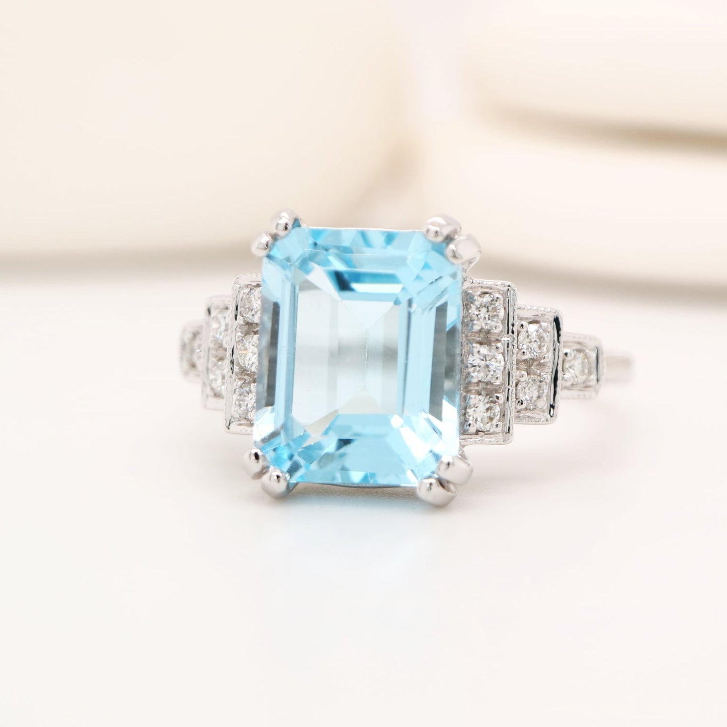 Ring with a large blue gemstone and diamond accents on a light background