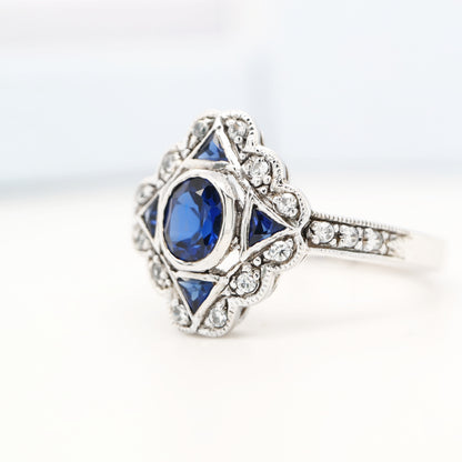 Art deco sapphire starburst white gold ring with diamond halo