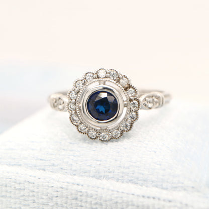 Laboratory grown blue sapphire with CZ halo in sterling silver ring