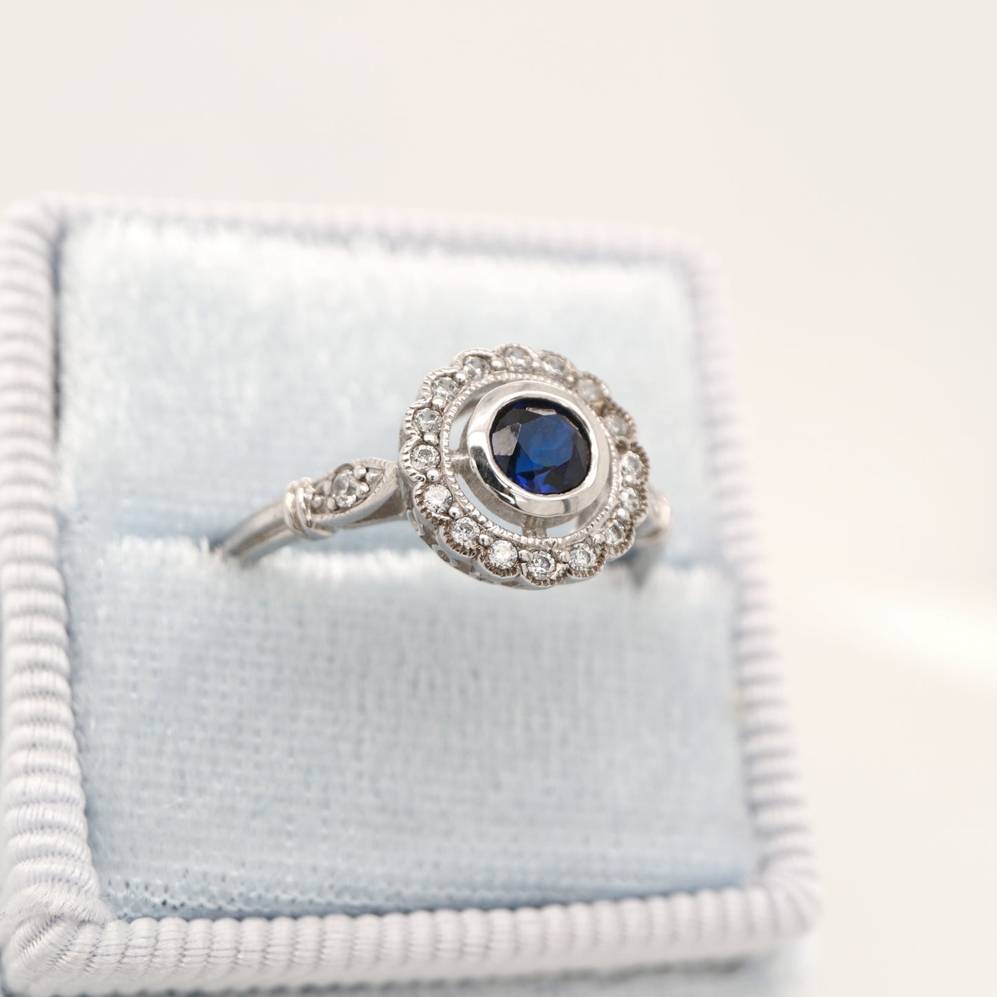 Laboratory grown blue sapphire with CZ halo in sterling silver ring