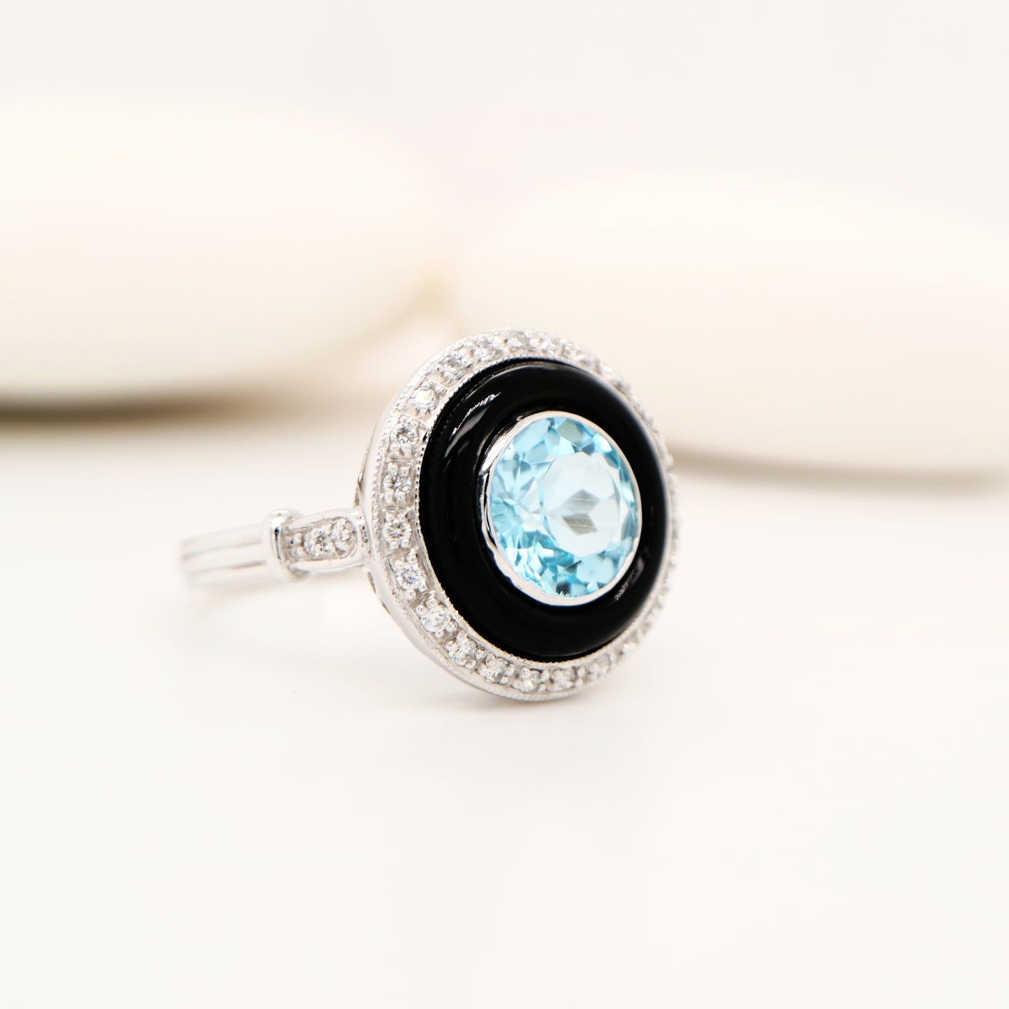 Round blue topaz ring with onyx and diamond halo in 9k white gold