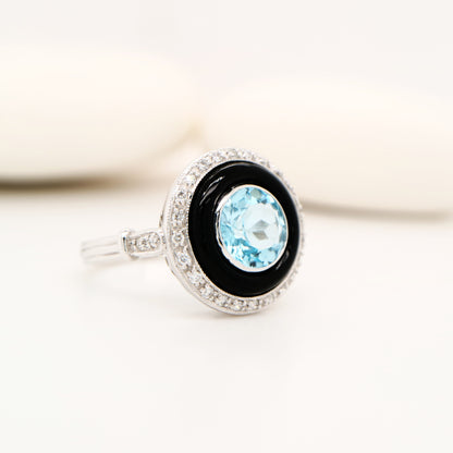 Round blue topaz ring with onyx and diamond halo in 9k white gold