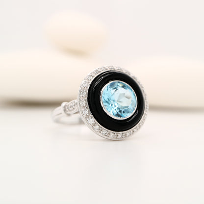Round blue topaz ring with onyx and diamond halo in 9k white gold