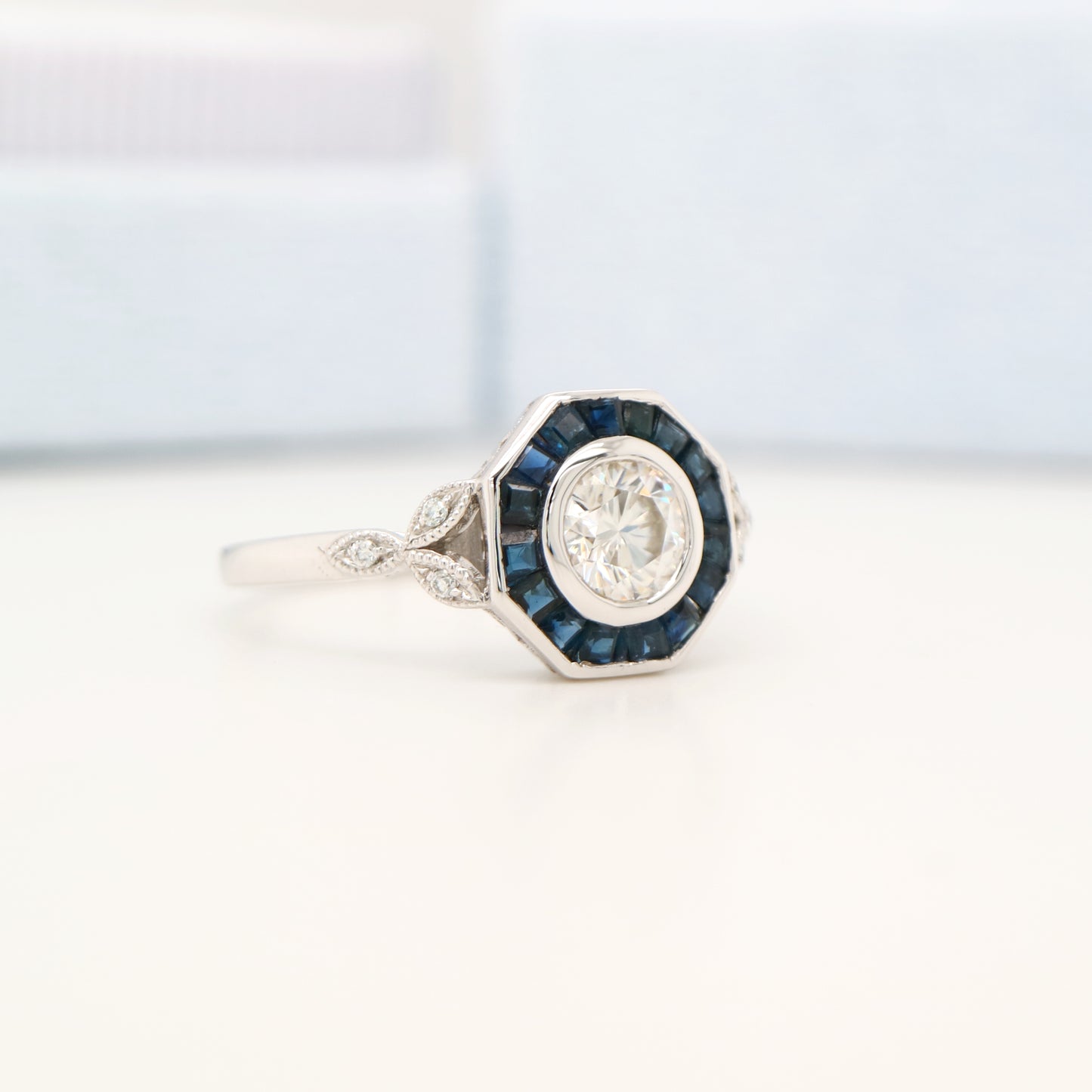 Target ring with channel set sapphires and moissanite in white gold