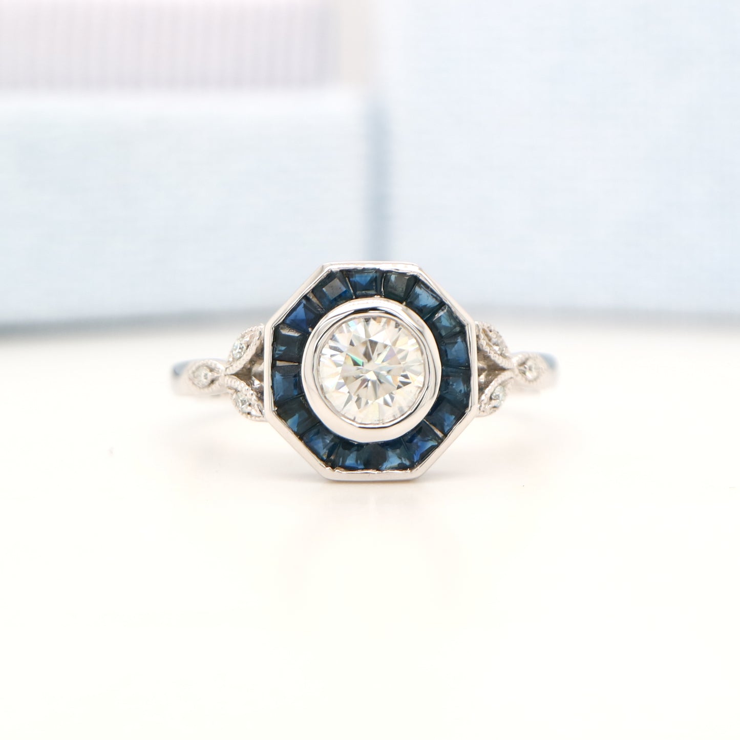 Target ring with channel set sapphires and moissanite in white gold
