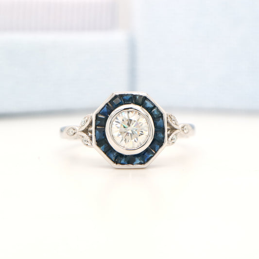 Target ring with channel set sapphires and moissanite in white gold