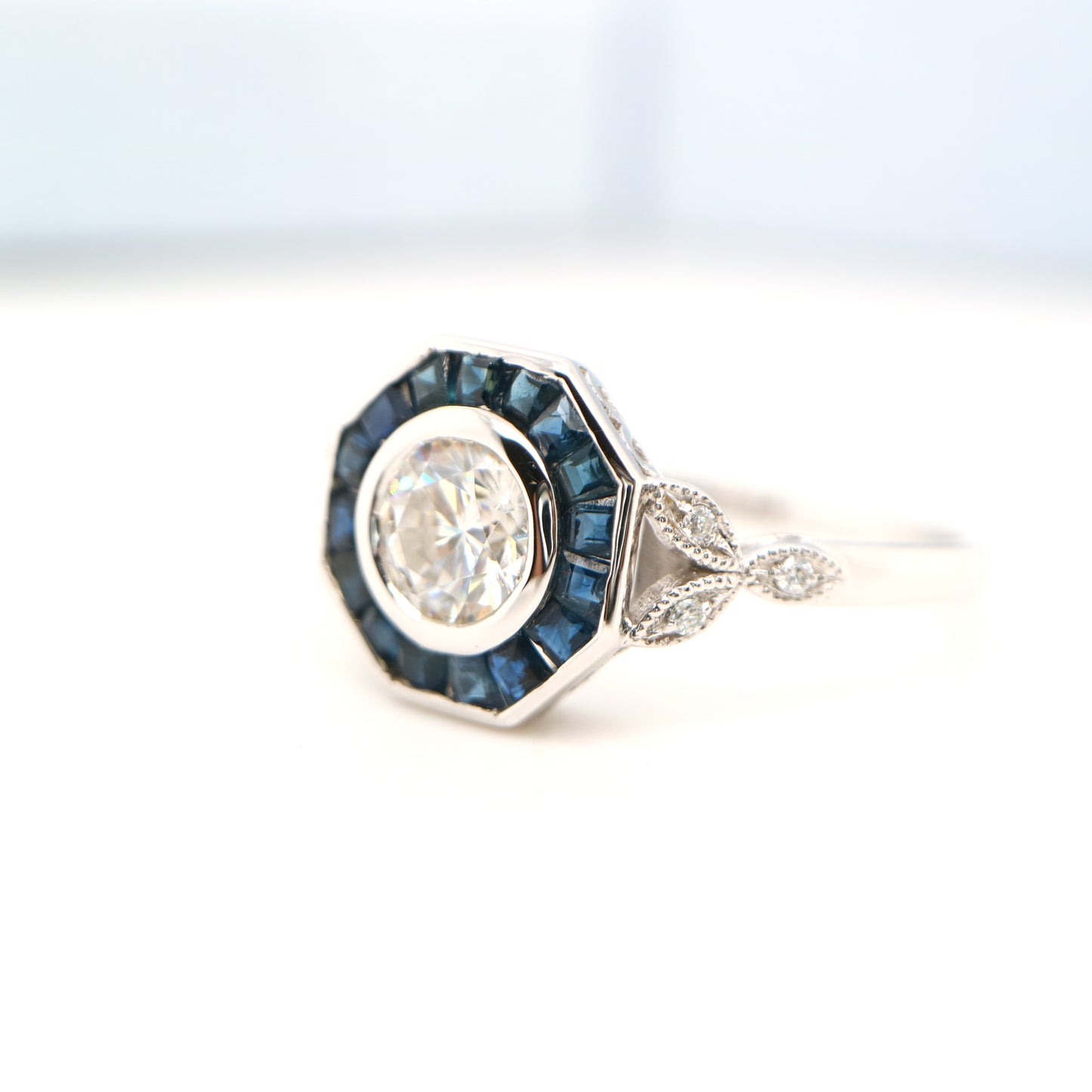 Target ring with channel set sapphires and moissanite in white gold