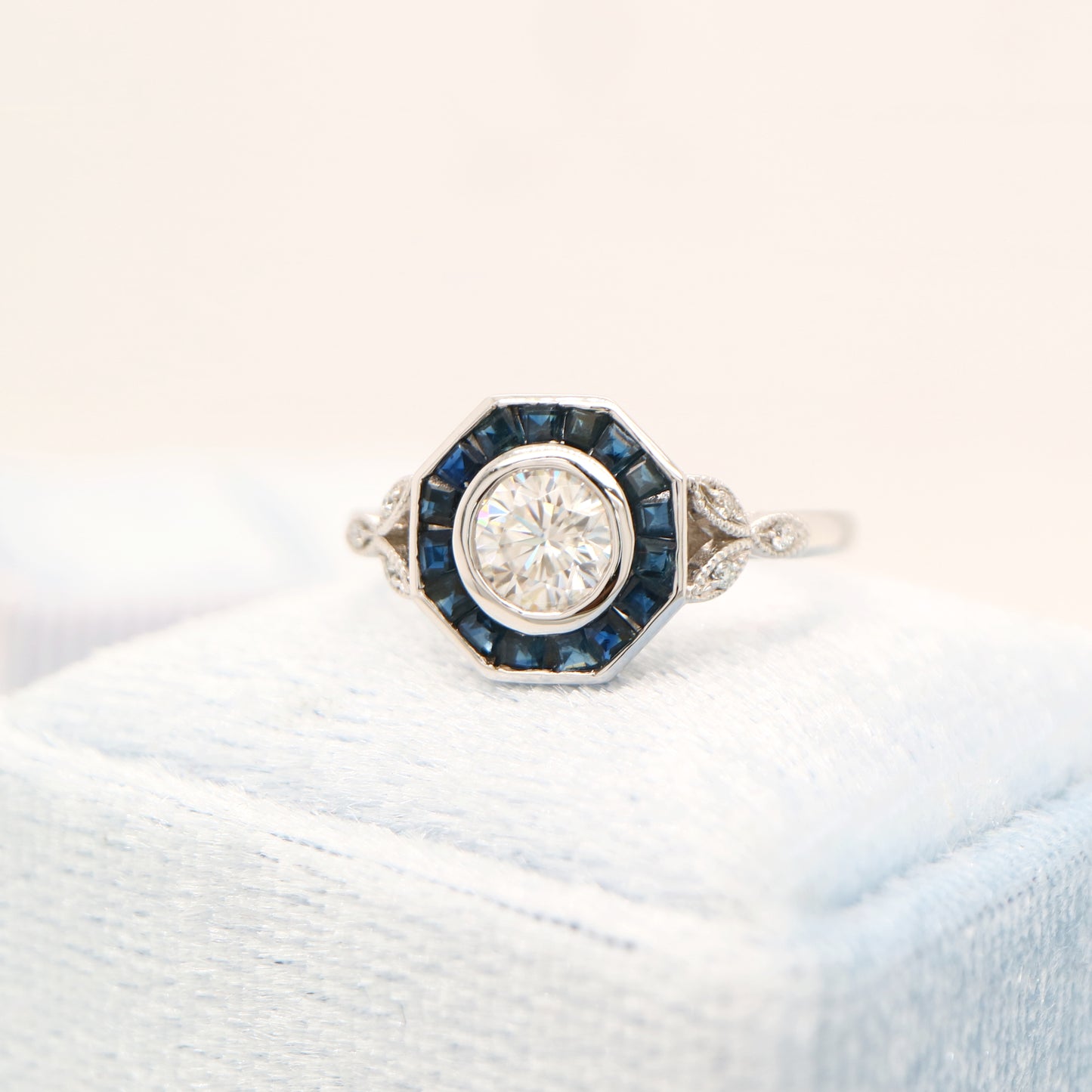 Target ring with channel set sapphires and moissanite in white gold
