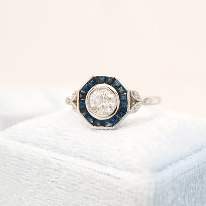 Target ring with channel set sapphires and moissanite in white gold