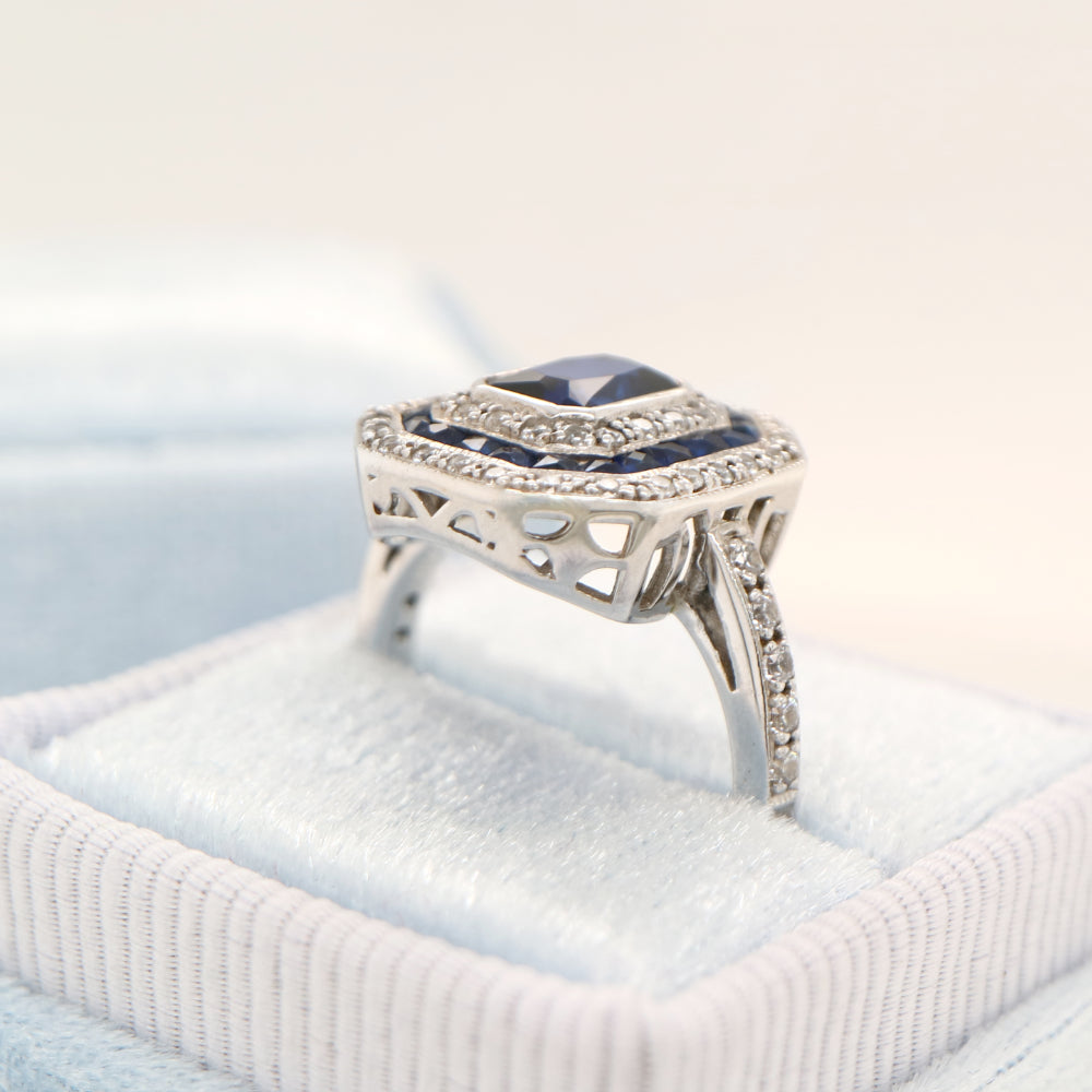 Sapphire cocktail ring with gemstone stripe halo's