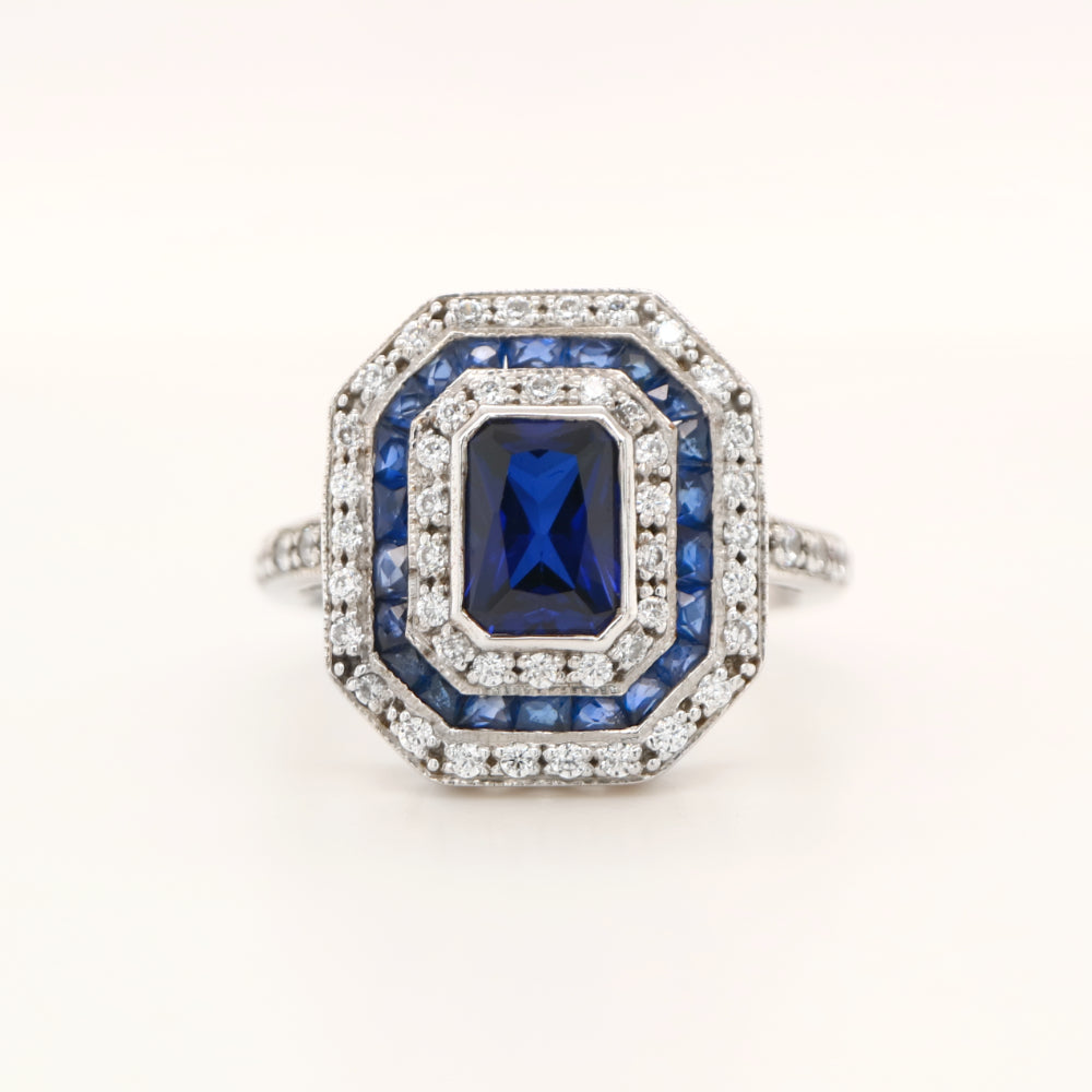 Sapphire cocktail ring with gemstone stripe halo's