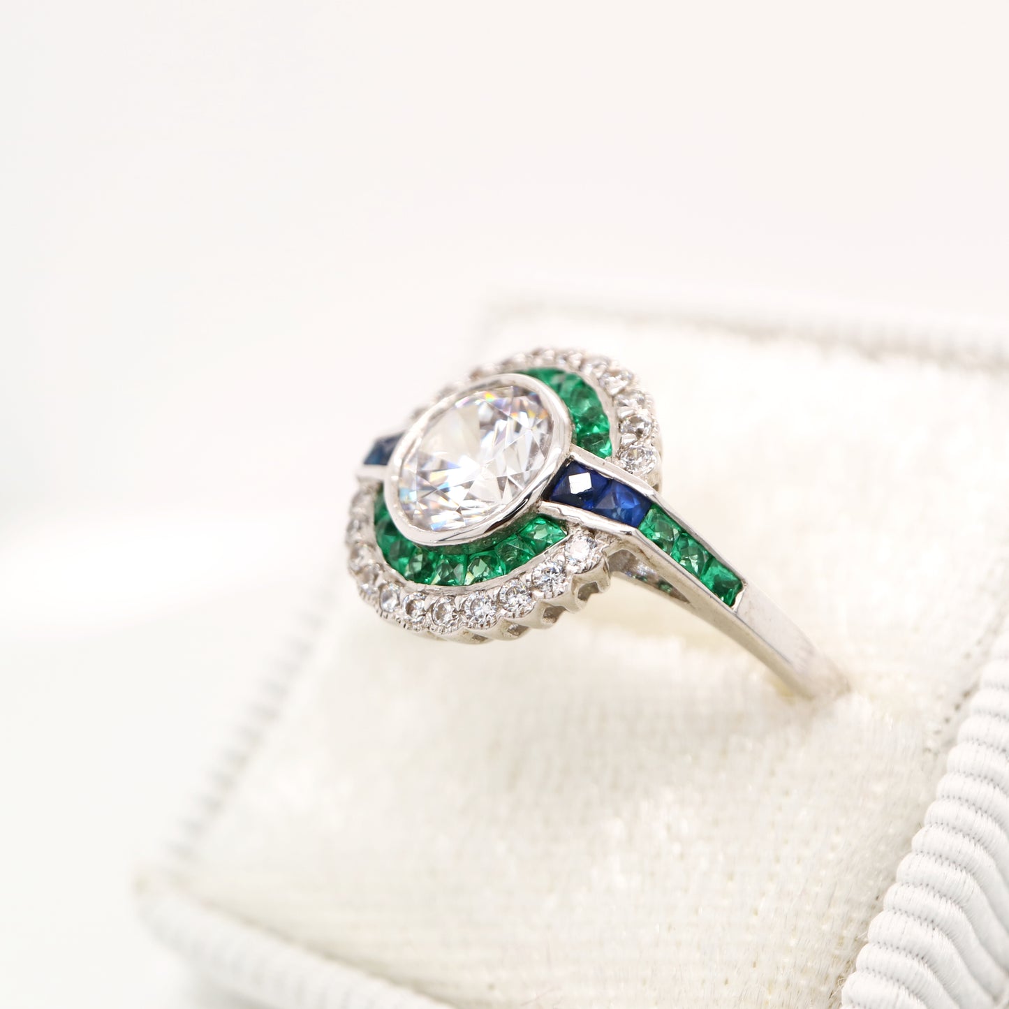 Moissanite and emerald target ring with sapphire accents in white gold