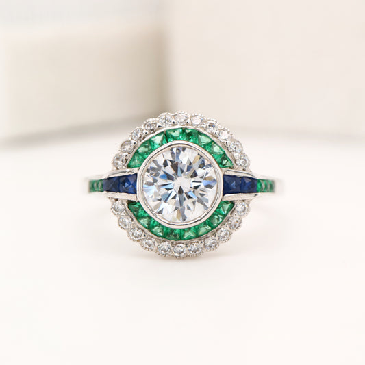 Moissanite and emerald target ring with sapphire accents in white gold