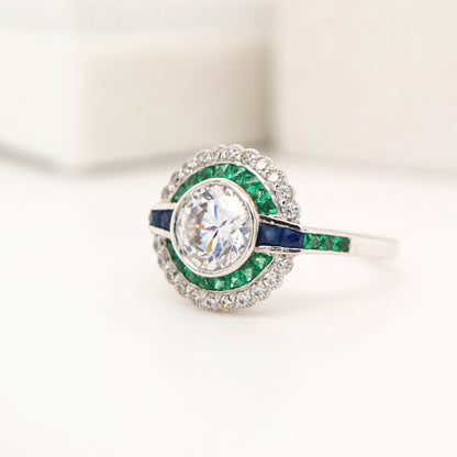 Moissanite and emerald target ring with sapphire accents in white gold