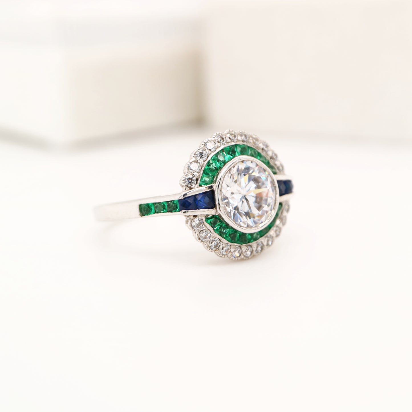 Moissanite and emerald target ring with sapphire accents in white gold
