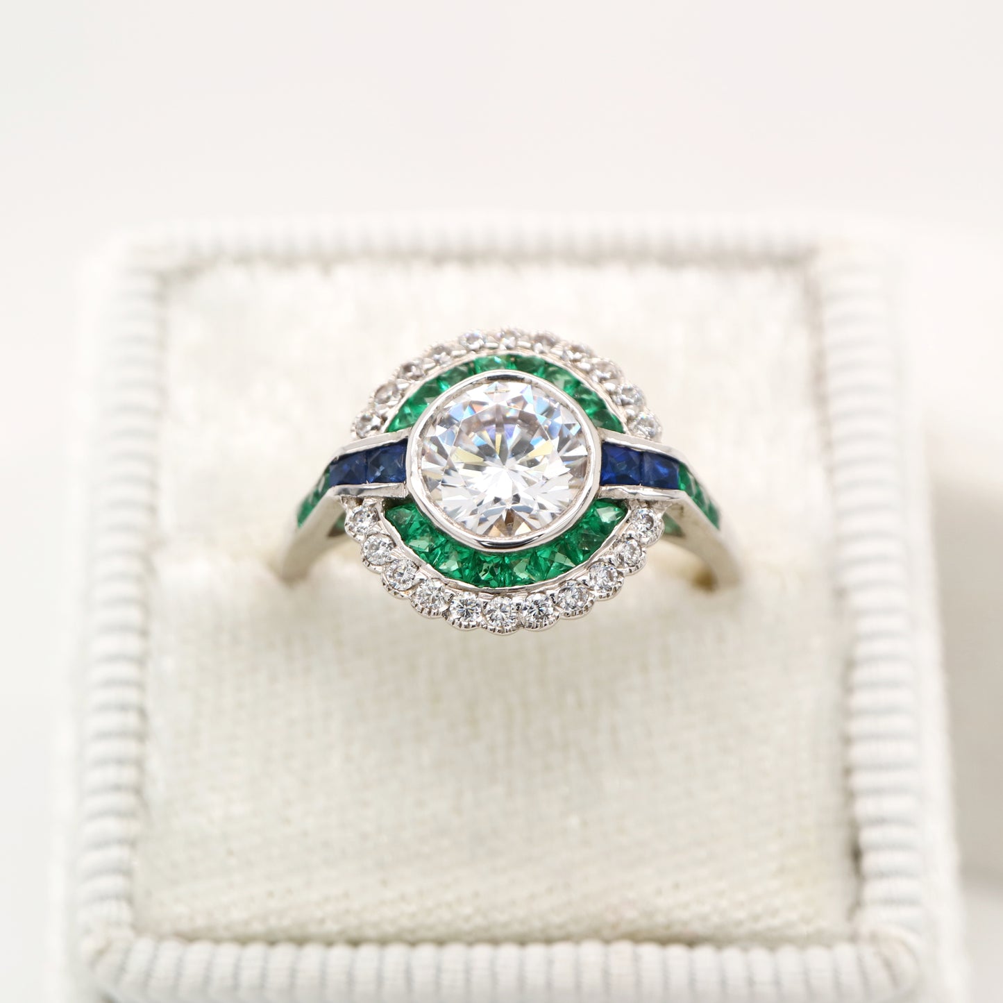 Moissanite and emerald target ring with sapphire accents in white gold