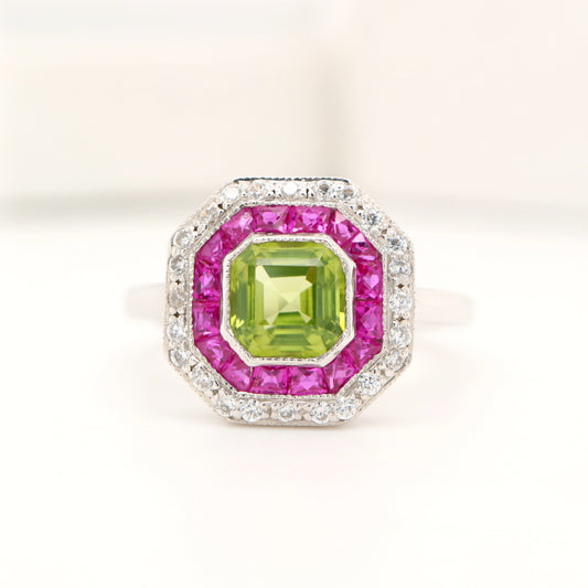 Peridot target ring with ruby and diamond halo in white gold