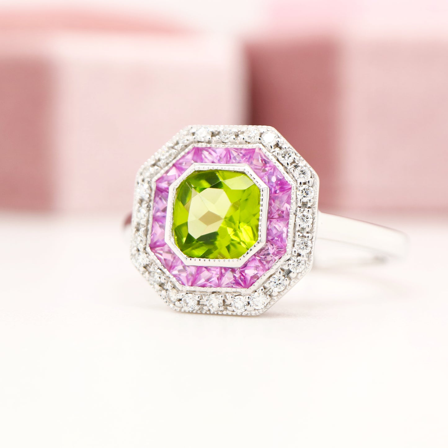 Peridot target ring with pink sapphires and diamond halo in white gold