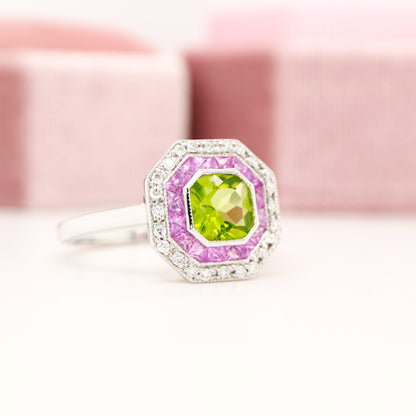 Peridot target ring with pink sapphires and diamond halo in white gold
