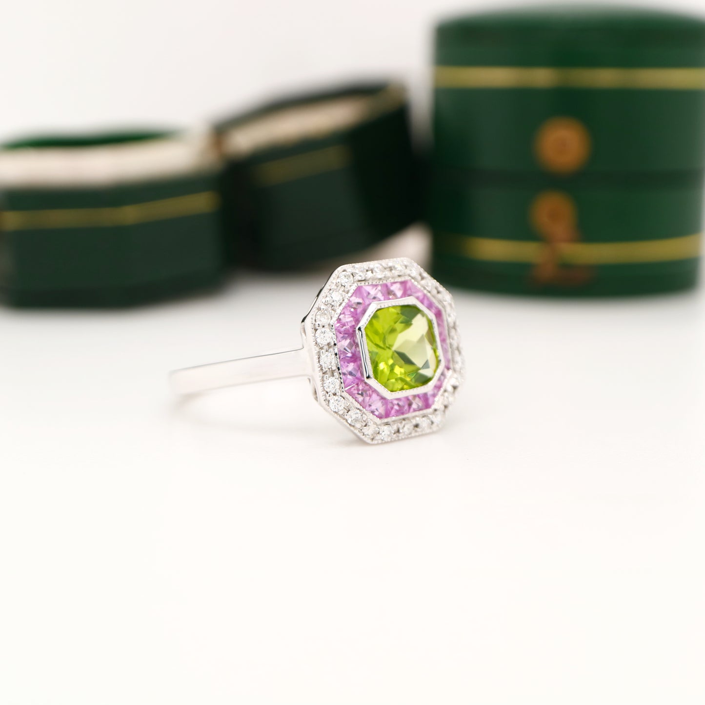 Peridot target ring with pink sapphires and diamond halo in white gold
