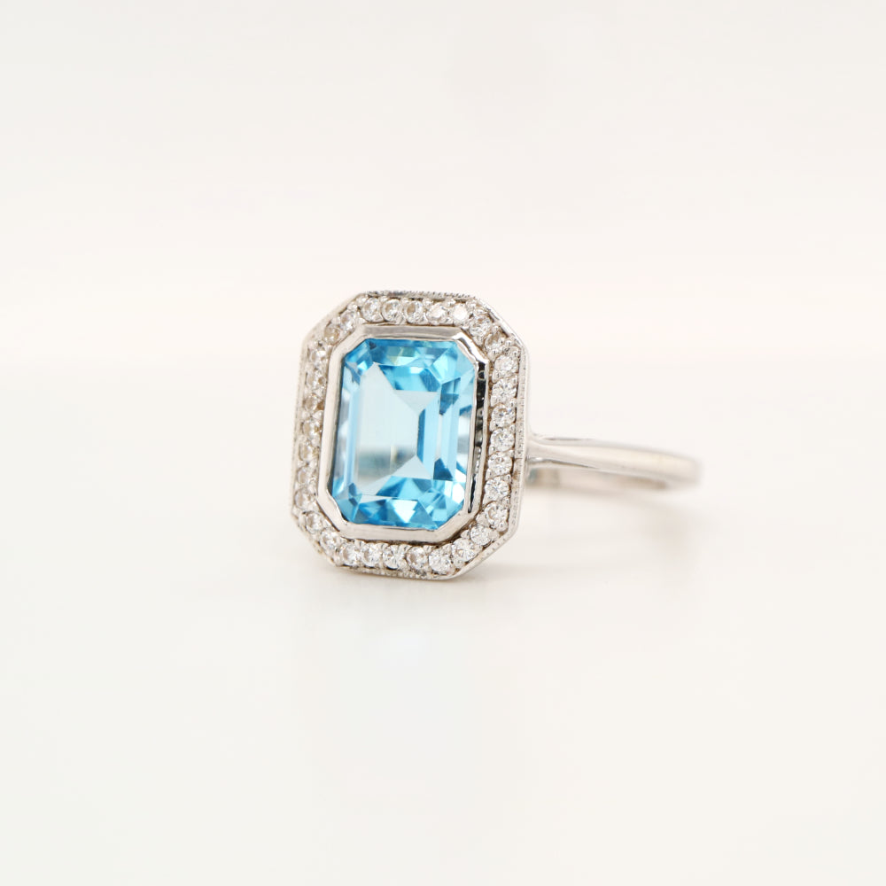 Blue topaz with diamond halo in white gold ring
