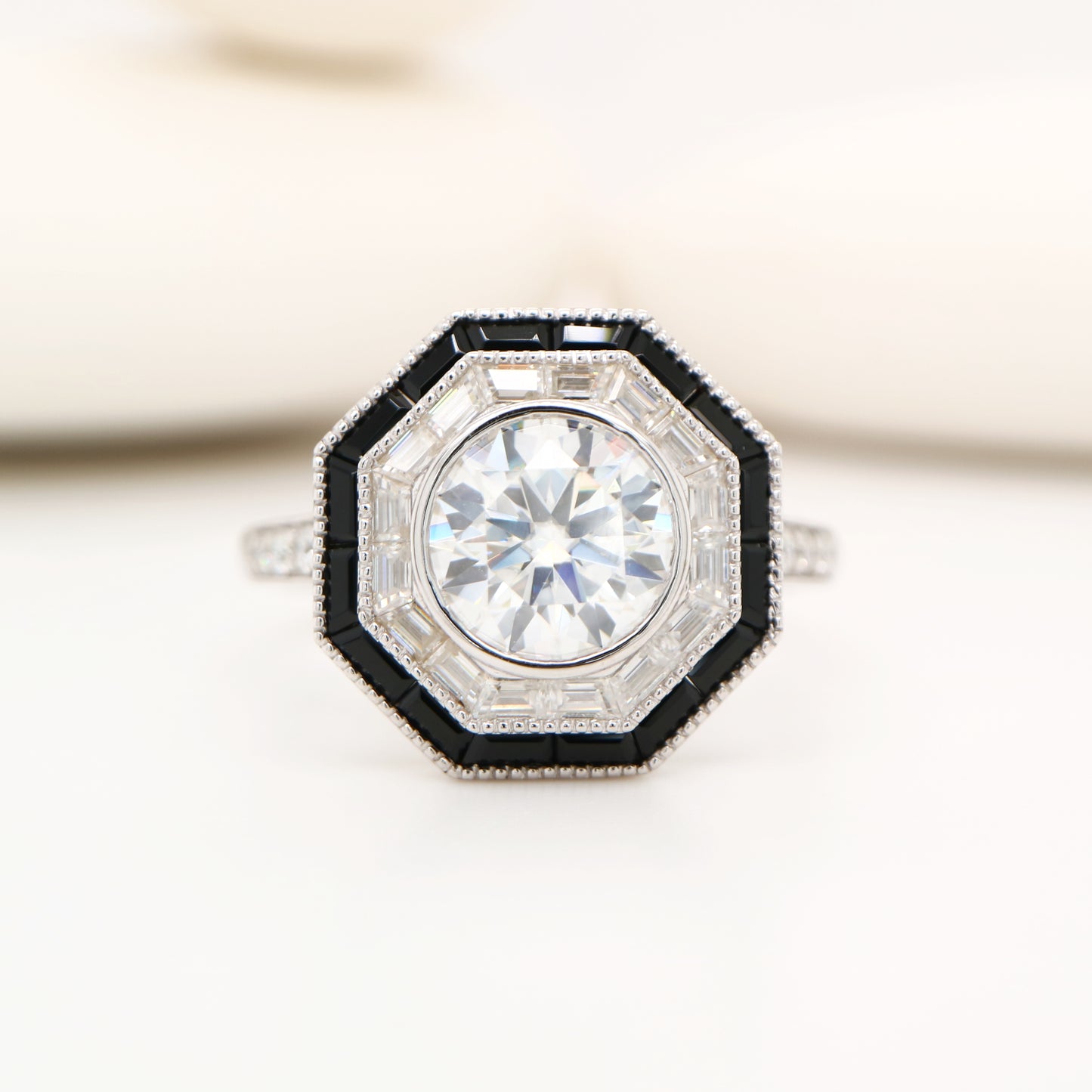 Moissanite target ring with moissanite and onyx halo in white gold