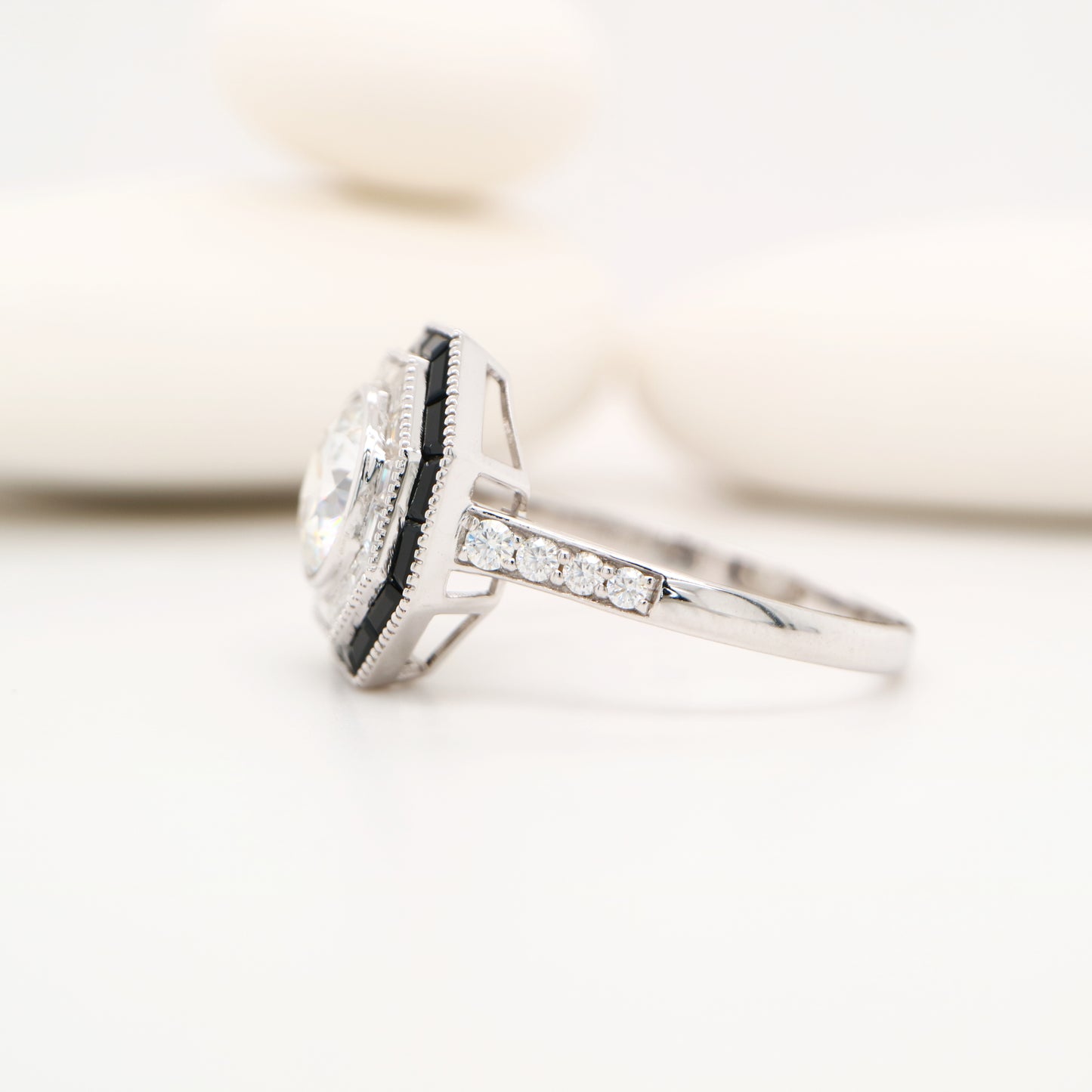 Moissanite target ring with moissanite and onyx halo in white gold