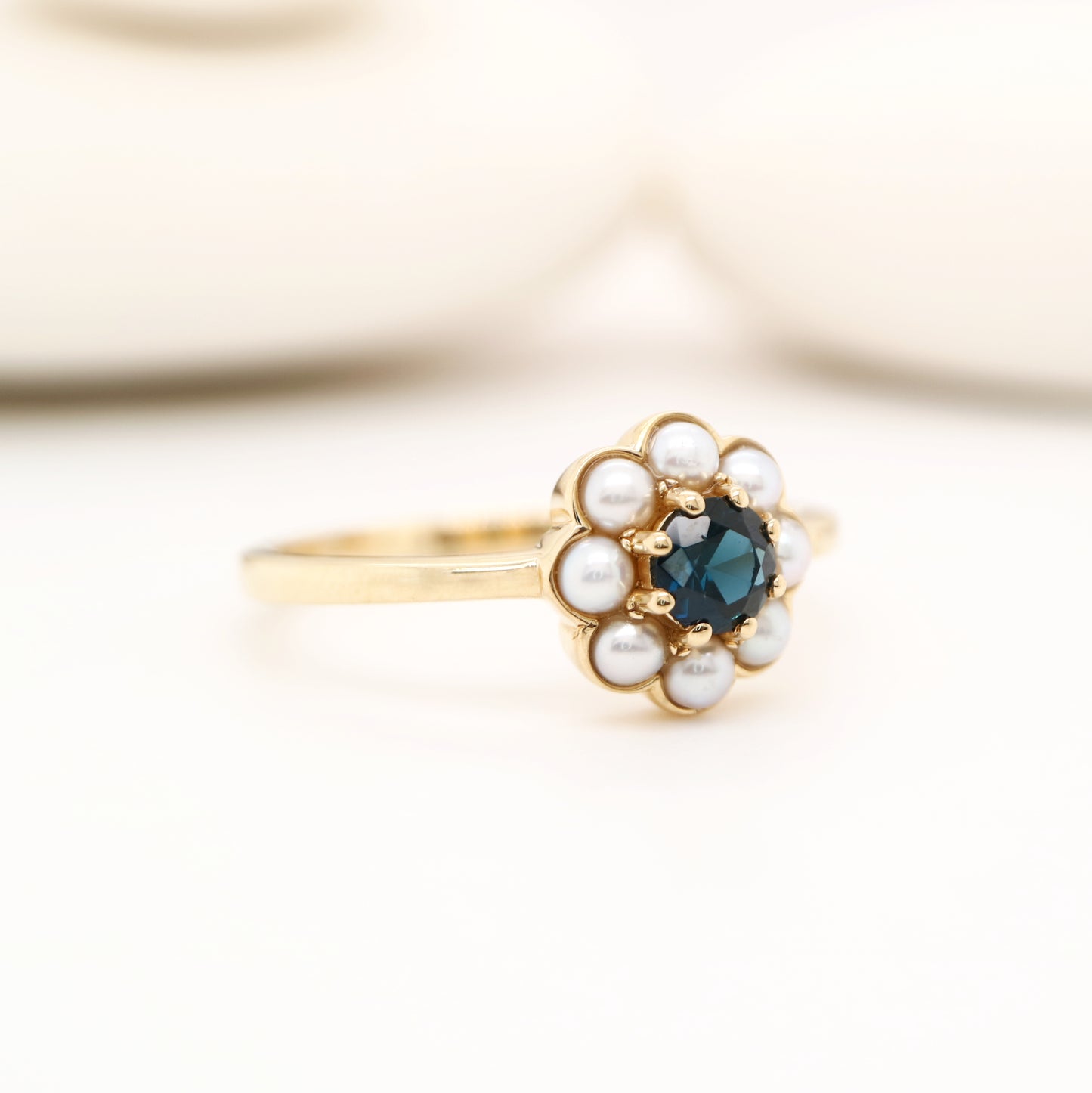 Blue sapphire with pearl halo ring in 9k yellow gold